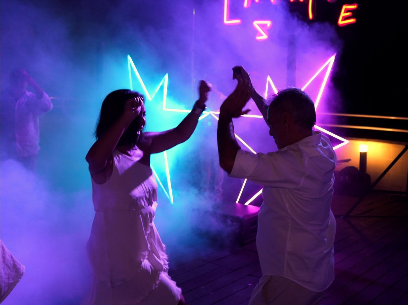 Pareja bailando entre las estrellas de neón